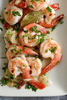 a white plate topped with shrimp and garnish