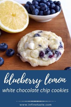 blueberry lemon white chocolate chip cookies on a cutting board with fresh blueberries and lemons