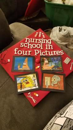 a red book sitting on top of a couch next to other books and pictures in front of it