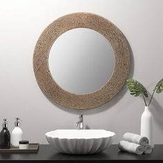 a bathroom with a round mirror above the sink