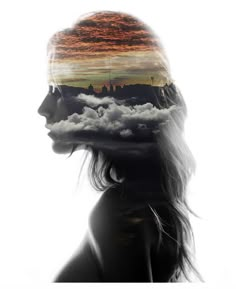 a woman's head with clouds in the shape of a city and an orange sky