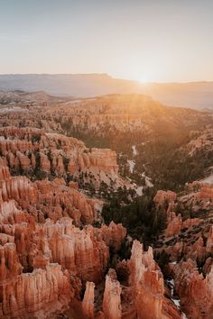 the sun is setting over hoodoos and canyons in the valley below, as seen from above