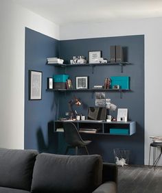 a living room filled with furniture and shelves on top of it's walls in front of a blue wall