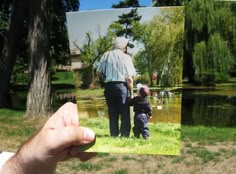 a person holding up a card with an image of a man and child in the park