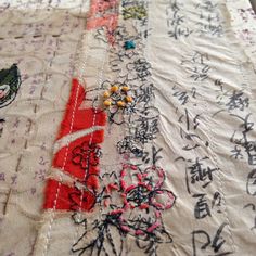 a close up of a piece of cloth with writing on it and flowers in the middle