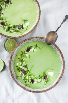 two bowls filled with green soup and garnish