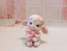 a stuffed animal with a pink bow around its neck