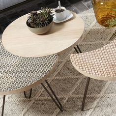 two tables with plants on them in front of a window