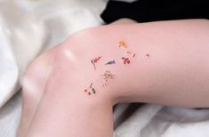 a woman's leg with small flowers on it