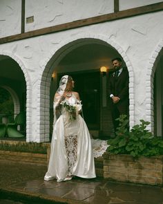 a bride and groom are standing in front of a building