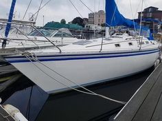 a sailboat docked at a dock with other boats in the background