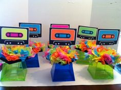 there are four small vases with colorful decorations on top of each one, and an mp3 player in the middle