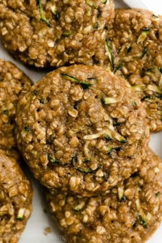 some cookies are on a white plate and have green sprigs on top of them