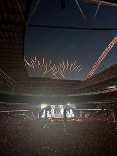 fireworks are lit up in the sky above an arena