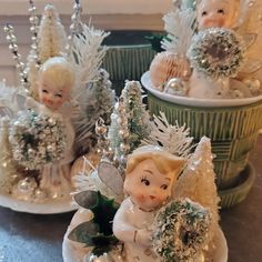 three little angel figurines sitting next to each other on top of a table