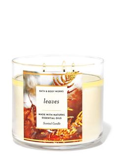 a candle that is sitting in front of a white background with the words leaves on it