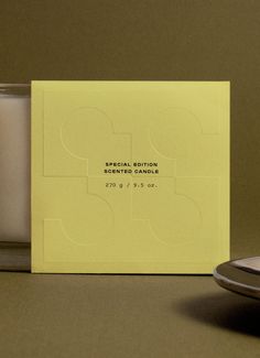 a candle sits next to a yellow card with the words special edition written on it