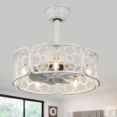 a white chandelier hanging from the ceiling in a bedroom