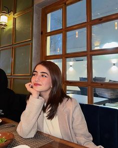 a woman sitting at a table with food in front of her