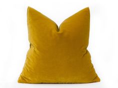 a yellow pillow sitting on top of a white surface