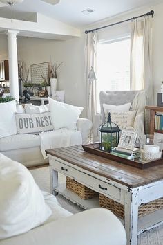 a living room filled with white furniture and pillows