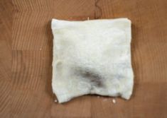 a piece of white material sitting on top of a wooden table