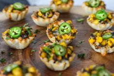 small appetizers on a wooden platter with green peppers and jalapenos