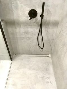 a walk in shower sitting inside of a bathroom next to a wall mounted faucet