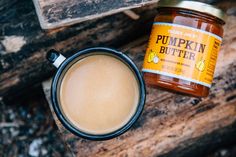 a cup of coffee next to a jar of pumpkin butter