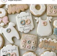 decorated baby shower cookies are displayed on a table