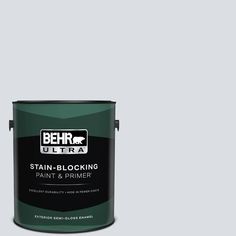 a can of behr ultra stain - blocking paint and primer on a gray background