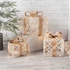 three wrapped presents sitting next to a christmas tree