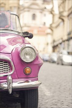 a pink car is parked on the side of the road