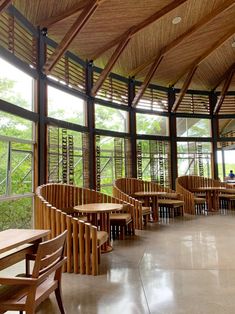 the inside of a restaurant with wooden tables and chairs, wood slats on the ceiling