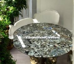 a marble table with chairs around it in the middle of a room next to a potted plant