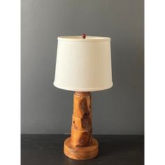 a lamp made out of wood with a white lampshade sitting on top of it