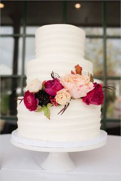 a white wedding cake with flowers on top