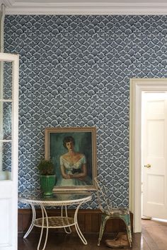 a room with blue and white wallpaper and a painting on the wall next to it