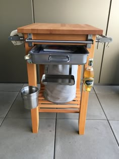 an outdoor cooking station with pots and pans on the floor next to a wall