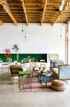 a living room filled with lots of furniture and decor on top of tile flooring