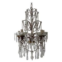 a chandelier with candles hanging from it's sides and crystal drops on the bottom