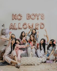 a group of women sitting on the floor in front of a sign that says no boys allowed