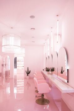 a room with pink chairs and mirrors in it