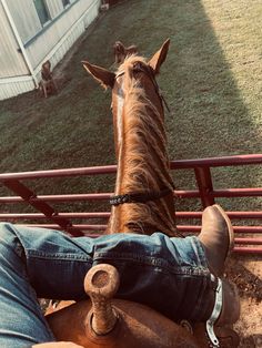 a man sitting on the back of a brown horse