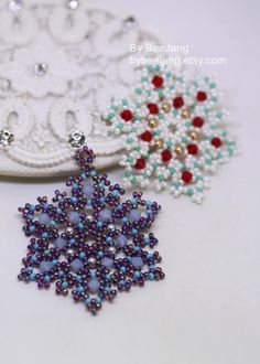 two beaded snowflakes sitting next to each other