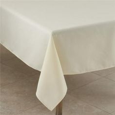 a white table cloth on top of a wooden table with tile flooring in the background