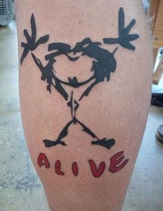 a man with a tattoo on his leg that says alive and two birds in the shape of a heart