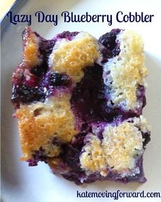 a piece of blueberry cobbler on a plate with the words lazy day blueberry cobbler