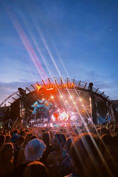 a large group of people standing on top of a stage under a bright blue sky