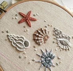 three seashells and one starfish are on the embroidery